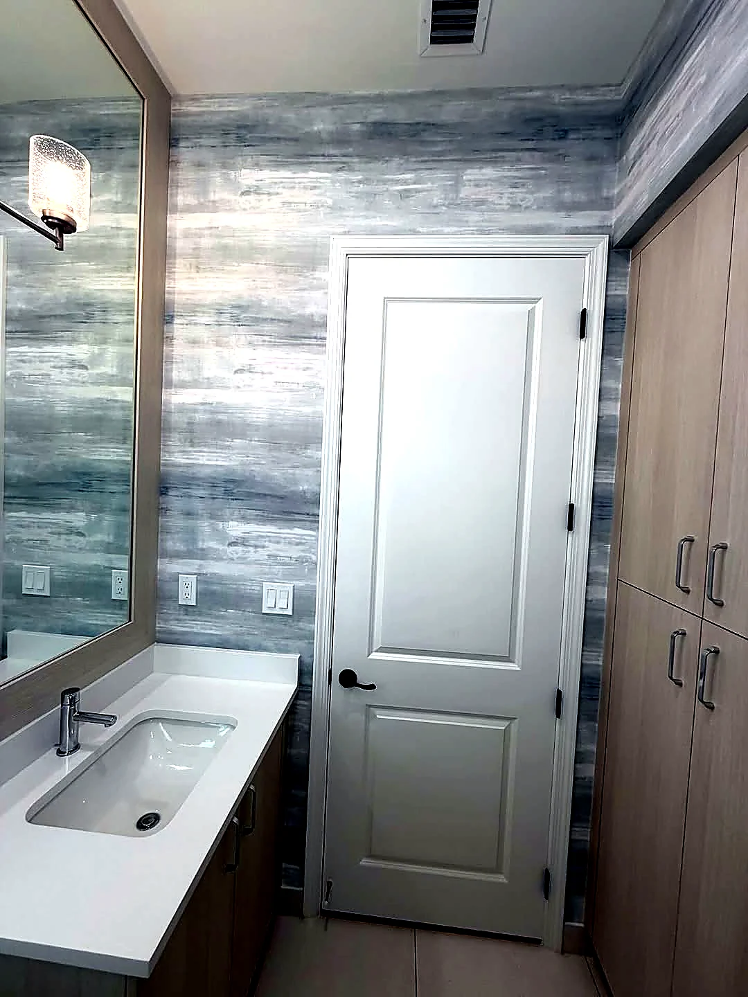 Brushed blue-gray textured wallcovering installed in a bathroom